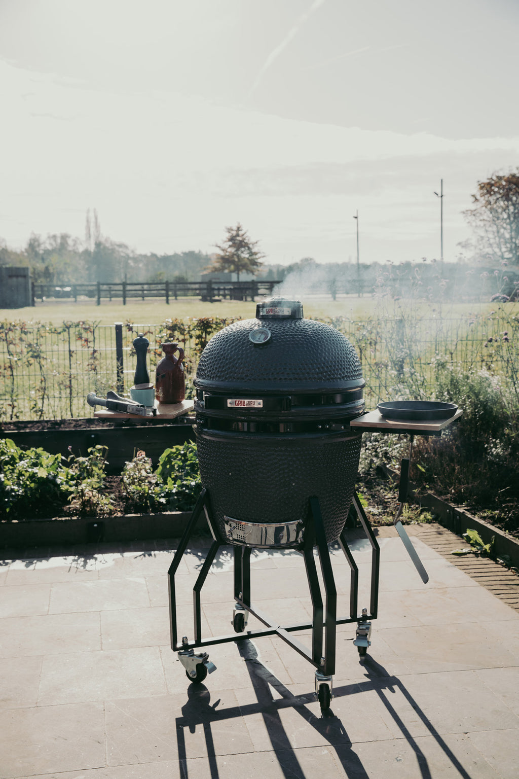 Large barbecue grill on a patio with a garden in the background
