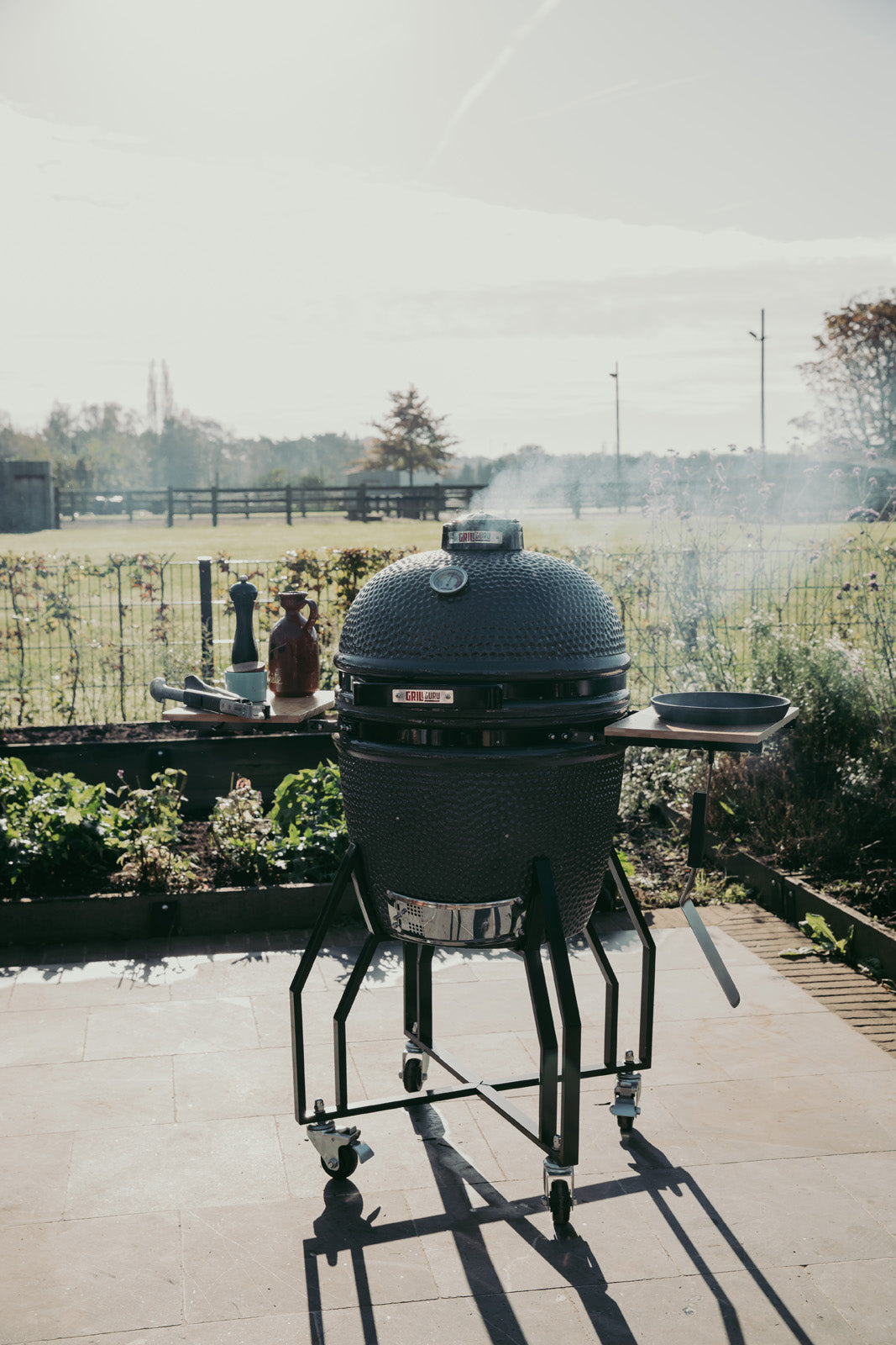 Large barbecue grill on a patio with a garden in the background