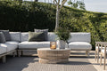 Outdoor patio with a sectional sofa, coffee table, and potted plant.