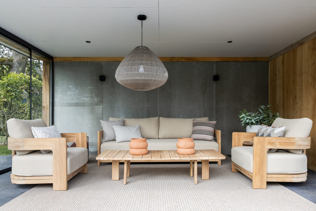 Modern outdoor furniture set with wooden frames and light-colored cushions in a stylish patio setting.