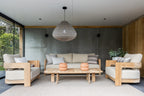 Modern outdoor furniture set with wooden frames and light-colored cushions in a stylish patio setting.