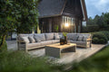 Outdoor patio with a sectional sofa, coffee table, and decorative elements in a garden setting.